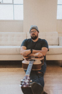 picture of dave hinrich with guitar sitting on his legs